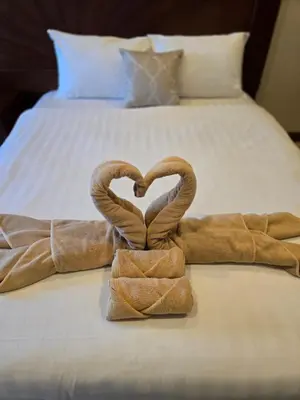 two towels in the shape of a heart on a bed at NJoy Boutique Guesthouse in Patong Beach