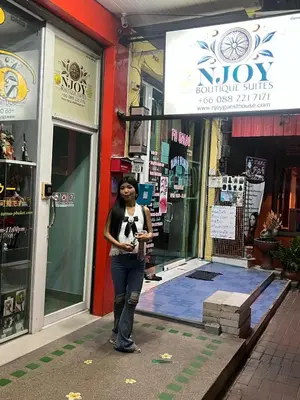 a woman standing in front of a store at NJoy Boutique Guesthouse in Patong Beach