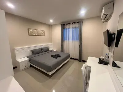 a bedroom with a bed and a television in it at NJoy Boutique Guesthouse in Patong Beach
