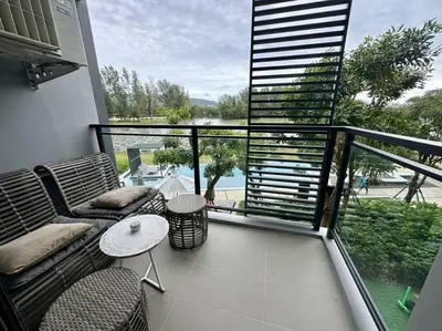a balcony with a couch and chairs and a table at 2bedrooms Cassia Residence lake view in Phuket