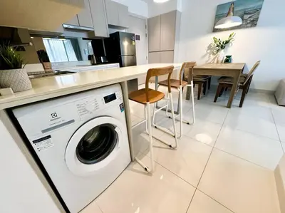 a kitchen with a washing machine and a dining table at 2bedrooms Cassia Residence lake view in Phuket