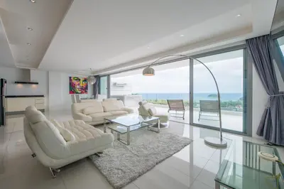a living room with white furniture and large windows at Kata Beach TheView luxurious Condonomium in Kata Beach