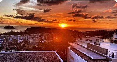 a sunset over a city with the ocean at Kata Beach TheView luxurious Condonomium in Kata Beach