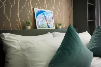 a bed with white and blue pillows in a room at City Gate Kamala N103 by Phuket Sabay Rent in Kamala Beach