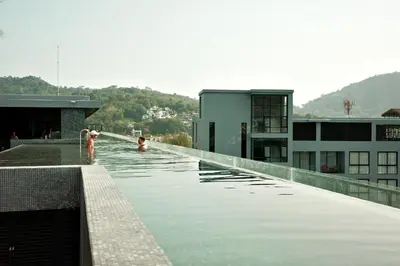 a pool on top of a building with people in the water at City Gate Kamala N103 by Phuket Sabay Rent in Kamala Beach