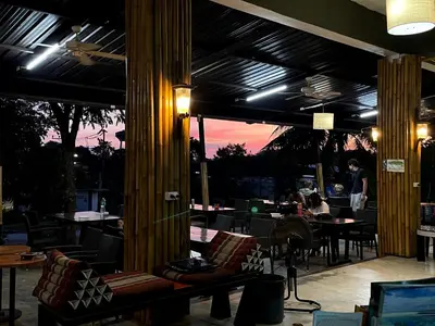 a restaurant with a patio with tables and chairs at Green Gen Hotel, Mueang Phuket in Phuket Town