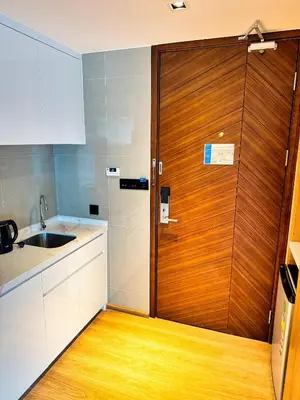 a kitchen with a wooden door and a sink at New stylish studio in La Vita 5 in Rawai Beach