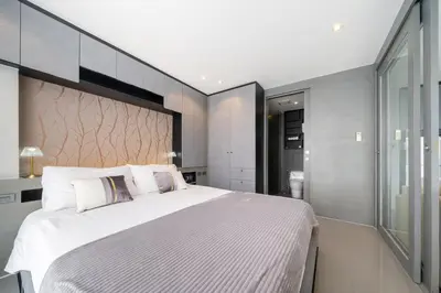 a bedroom with a large bed with a large headboard at Citygate Kamala Resort in Kamala Beach