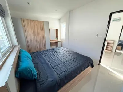 a bedroom with a blue bed and a window at Cozy House by Cody One in Thalang