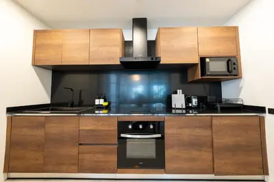 a kitchen with wooden cabinets and a stove top oven at House 158 Patong Pool Villa 4BR Near Beach in Patong Beach