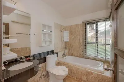 a bathroom with a tub and a toilet and a sink at Golden Horizon Villa 02 in Ban Ao Kung