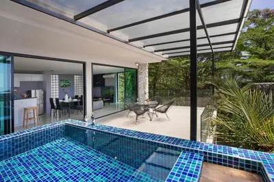 a house with a swimming pool next to a patio at Sea View & Tropical Bliss - 2BR Villa Natural Touch A4 at Kamala Hill in Kamala Beach