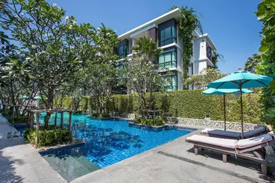 a pool in front of a building with an umbrella at Tropical Pool View 1BR Apartment TTL F303 in Rawai Beach Residence in Rawai Beach