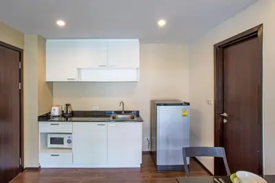 a kitchen with white cabinets and a refrigerator at Tropical Pool View 1BR Apartment TTL F303 in Rawai Beach Residence in Rawai Beach