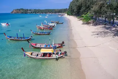 a group of boats in the water next to a beach at Tropical Pool View 1BR Apartment TTL F303 in Rawai Beach Residence in Rawai Beach