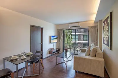 a living room with a couch and a table at Tropical Pool View 1BR Apartment TTL F303 in Rawai Beach Residence in Rawai Beach