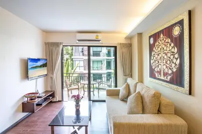 a living room with a couch and a table at Tropical Pool View 1BR Apartment TTL F303 in Rawai Beach Residence in Rawai Beach