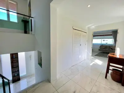 a living room with white walls and a staircase at 30 - Panoramic View Villa in Thalang in Thalang