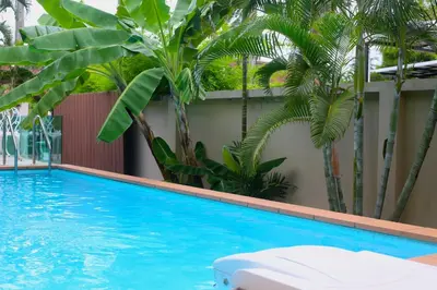 a swimming pool with palm trees in the background at 3 bedrooms Semi-Detached with Pool near Kamala Beach in Kamala Beach