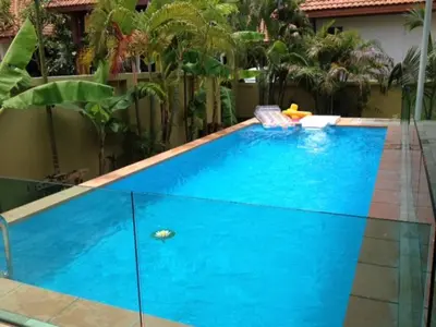 a large blue swimming pool in a backyard at 2 bedroom Semi-Detached Holiday Home with Pool near Kamala Beach in Kamala Beach
