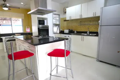 a kitchen with two red stools at a counter at 2 bedroom Semi-Detached Holiday Home with Pool near Kamala Beach in Kamala Beach
