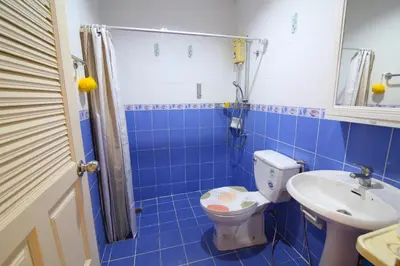 a blue tiled bathroom with a toilet and a sink at 2 bedroom Semi-Detached Holiday Home with Pool near Kamala Beach in Kamala Beach