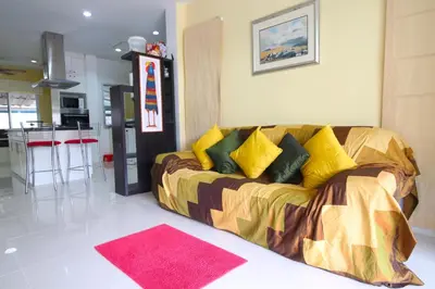 a couch with yellow pillows in a living room at 2 bedroom Semi-Detached Holiday Home with Pool near Kamala Beach in Kamala Beach