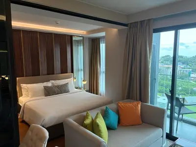 a hotel room with a bed and a couch at Mida 1 in Phuket Town