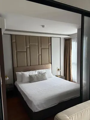 a bedroom with a large bed with white sheets at Mida 1 in Phuket Town