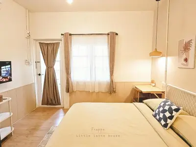 a bedroom with a large bed and a window at Little Latte House - Chalong in Ban Na Bon