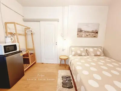 a small room with a bed and a microwave at Little Latte House - Chalong in Ban Na Bon