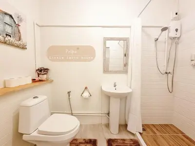 a white bathroom with a toilet and a sink at Little Latte House - Chalong in Ban Na Bon