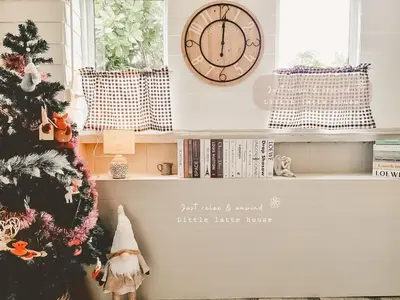 a shelf with a christmas tree and a clock at Little Latte House - Chalong in Ban Na Bon