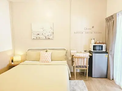 a small room with a bed and a microwave at Little Latte House - Chalong in Ban Na Bon