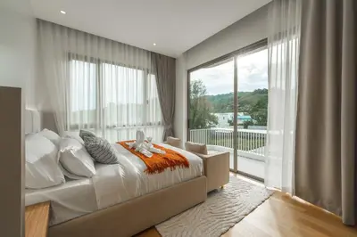 a bedroom with a bed and a large window at Nature's Rest Private Pool Villa Rawai in Phuket Town