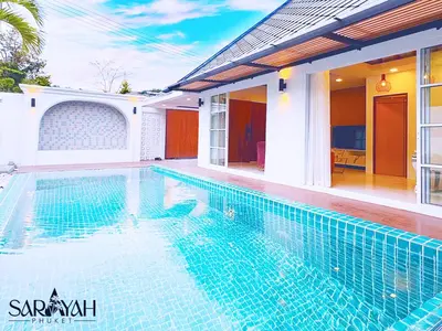 a swimming pool in front of a house at Sarayah Phuket Pool Villa in Phuket Town