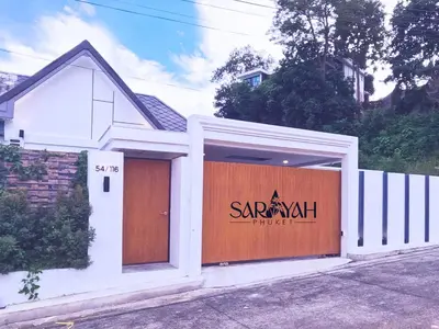 a saranak house with a garage with a sign on it at Sarayah Phuket Pool Villa in Phuket Town