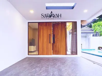 a sarikrit house entrance with a wooden door at Sarayah Phuket Pool Villa in Phuket Town