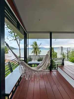 a hammock on a porch with a view of the ocean at Relax sunsmile Kohyaonoi in Ko Yao Noi