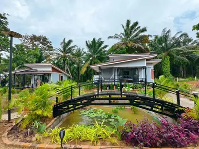 a house with a pond in front of it at Relax sunsmile Kohyaonoi in Ko Yao Noi