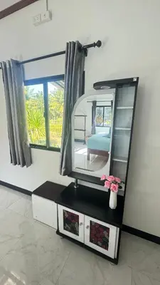 a dressing table with a mirror and a vase with flowers at Relax sunsmile Kohyaonoi in Ko Yao Noi
