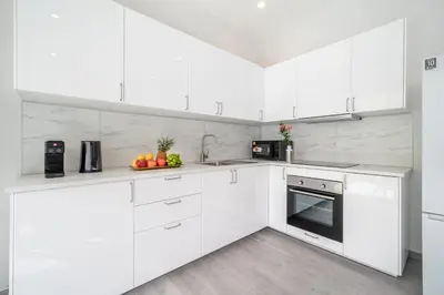a white kitchen with white cabinets and appliances at Brand New Villa in Ravai for a wonderful holiday 3 - bedroom in Ban Saiyuan (1)