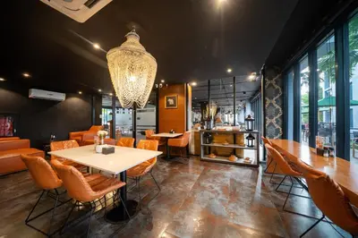 a restaurant with a table and chairs and a chandelier at CityGate Kamala in Kamala Beach