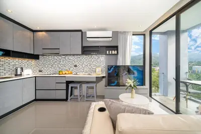a kitchen and living room with a couch at CityGate Kamala in Kamala Beach
