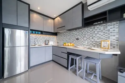 a kitchen with gray cabinets and a refrigerator at CityGate Kamala in Kamala Beach
