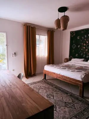 a bedroom with a bed and a table in it at The Rai Resort Rawai - Pool & Garden in Ban Bang Chak