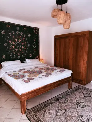 a bedroom with a bed with a floral headboard at The Rai Resort Rawai - Pool & Garden in Ban Bang Chak