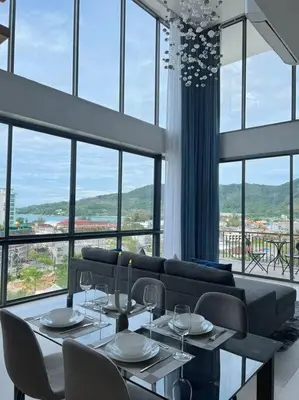 a living room with a couch and a table and chairs at Seaview 2 BR Spacious Modern Duplex near Kamala beach in Kamala Beach