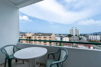 a balcony with a table and chairs and a view of a city at Condopatong in Patong Beach