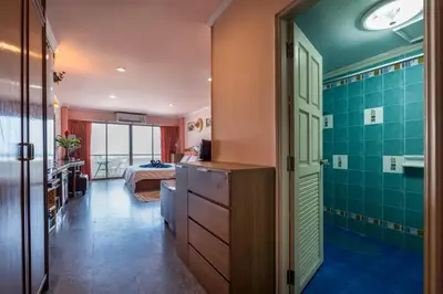 a bathroom with green tiles and a bedroom with a bed at Condopatong in Patong Beach